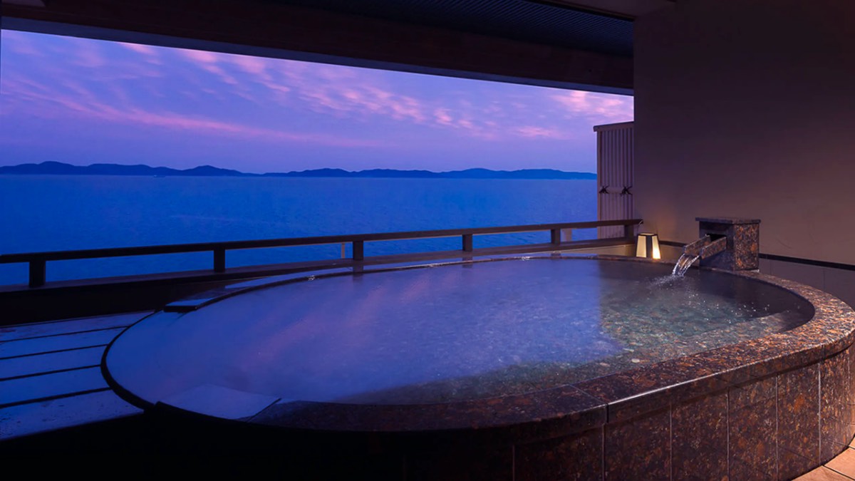 Private open-air bath, round stone tub at dusk